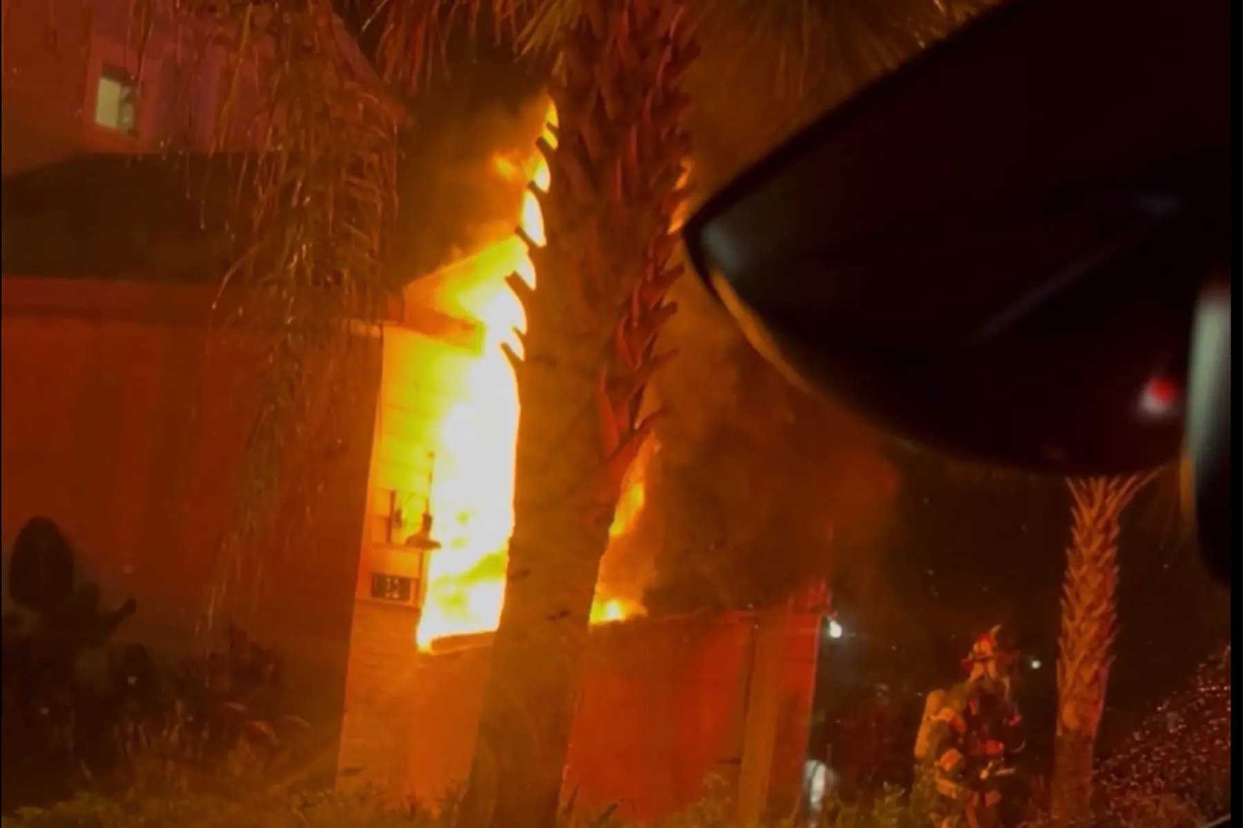 Fire visible at the exterior of a Beachwalk home during the emergency response.