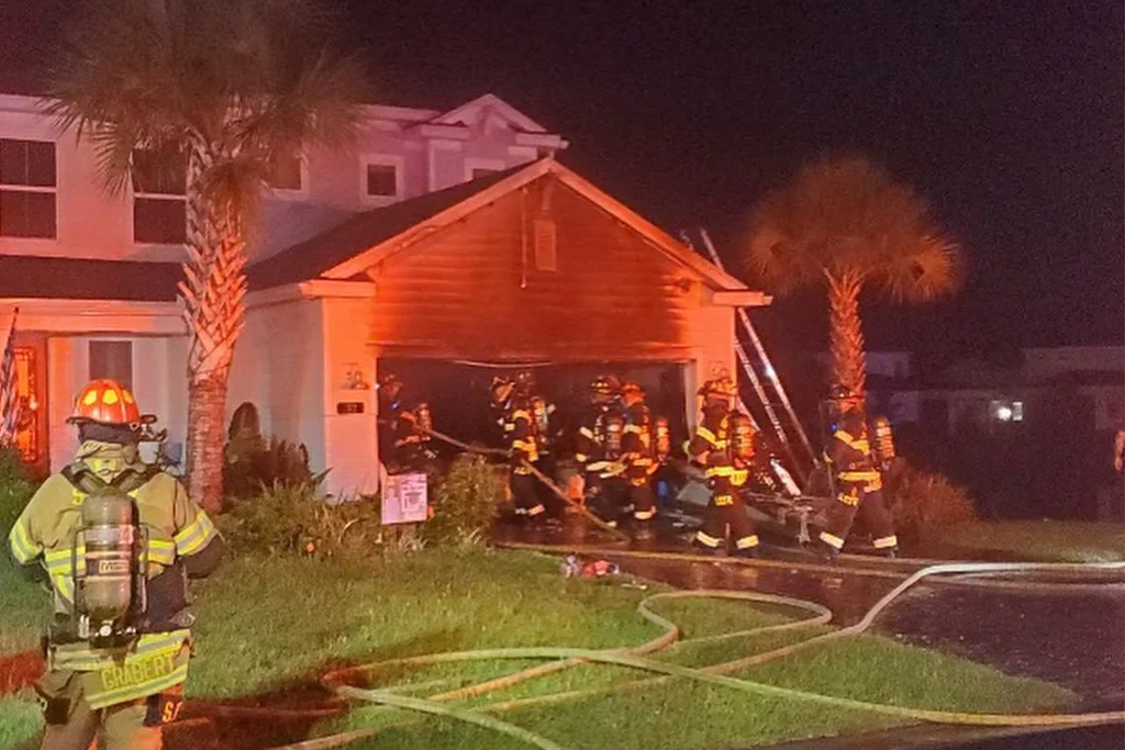 Firefighters working outside the damaged garage after the fire.